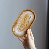 Handcrafted gold flakes resin trinket tray used as a jewelry organizer.